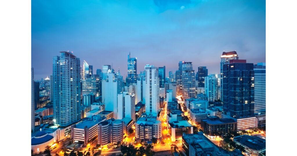 A panoramic view of the Manila skyline at dusk, showcasing modern skyscrapers and city lights