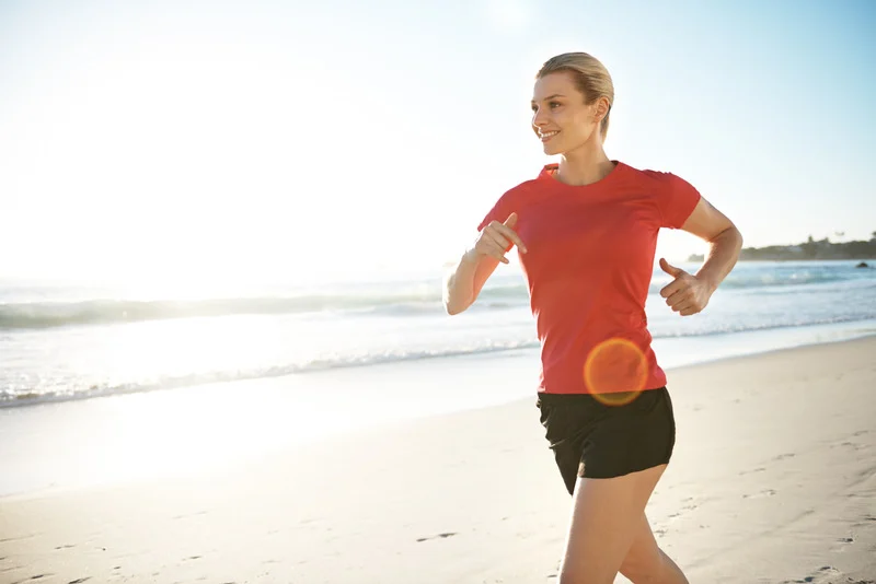 A woman jogging along the beach.