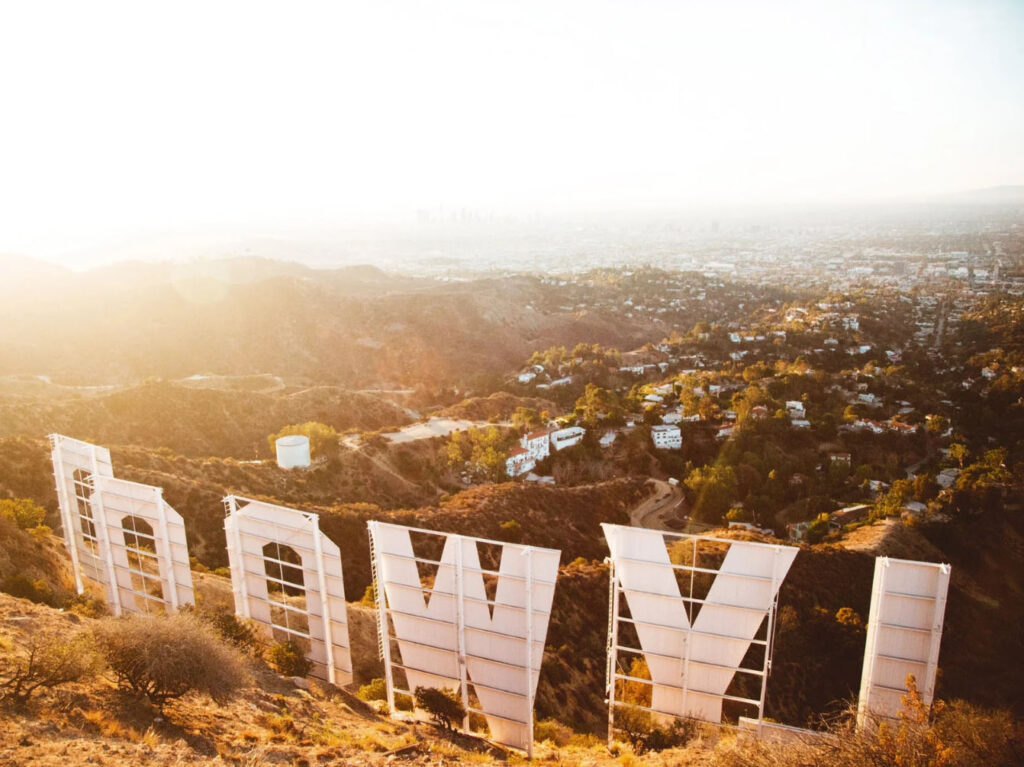 A view of the iconic Hollywood sign at sunset, with the sprawling city of Los Angeles visible in the background, showcasing the natural beauty of the area.
